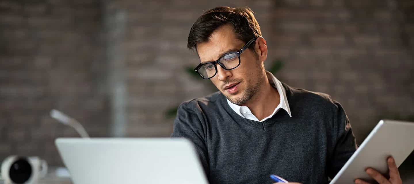 Ukjent mann med briller ser ned på en PC