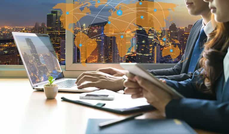 Ukjent person foran PC-skjerm. I bakgrunnen ses ukjent by på kveldstid