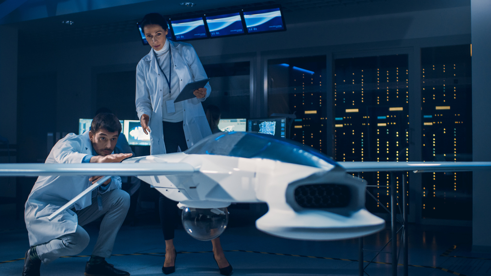 Aerospace engineers inspecting a drone prototype in a tech lab.